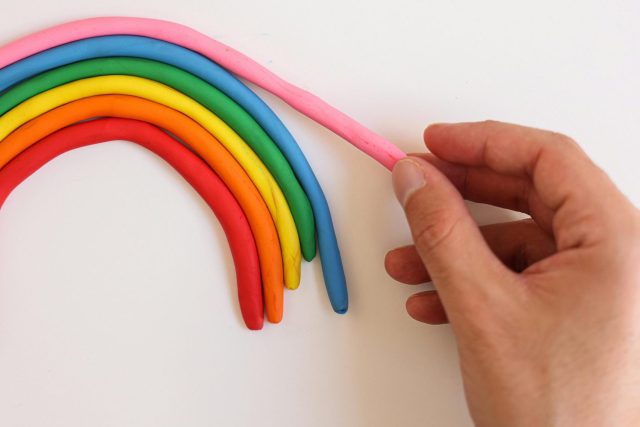 ידיים משחקות בפלסטלינה של קשת בענן